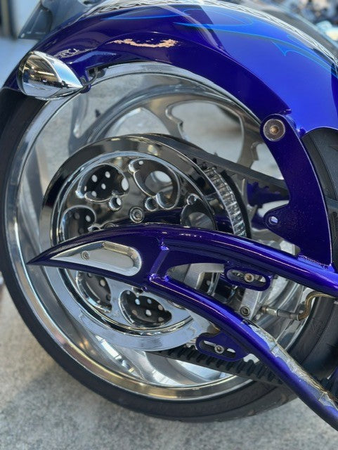 Close-up of custom motorcycle rear wheel with chrome and blue detailing – Knuckle Heads Customs